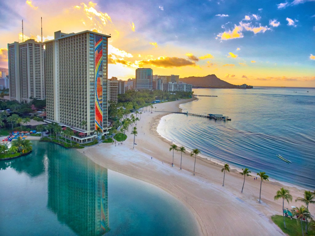 Las mejores destinaciones de vacaciones para estadounidenses: Hawái, Cancún y Hilton Hawaiian Village Waikiki Beach, Aerial, beach, ocean, palm trees, sunrise, blue sky
