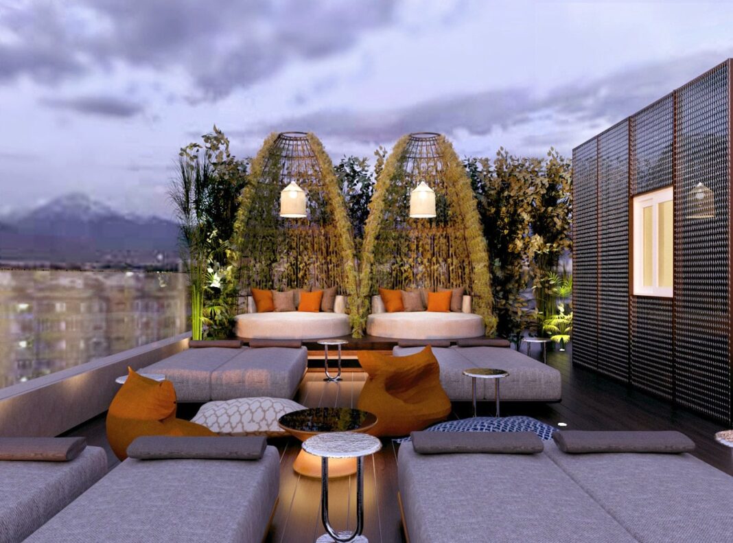 Adia Aluma Athens, Curio Collection by Hilton, lounge seating, outdoor seating, white decorative lighting, decorative wall, orange seat cushions, cocktail tables, plant wall, draped greenery